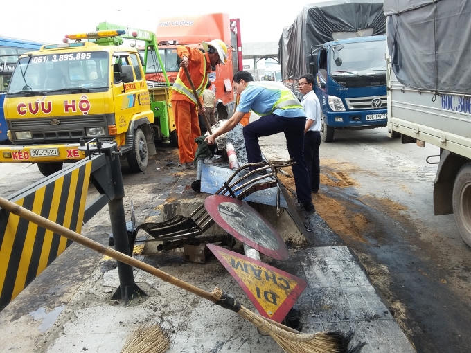 Biển báo giao thông bị tông gãy, dầu nhớt tràn ra đường.