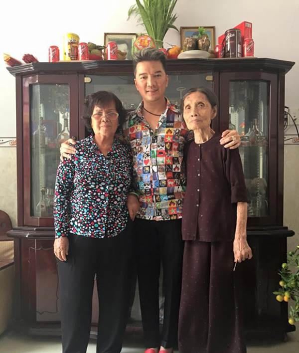Đàm Vĩnh Hưng chụp ảnh cùng mẹ ruột (áo hoa, bên trái) và vợ cả (áo nâu, bên phải) của cha trong một lần về thắp hương cho cha anh.