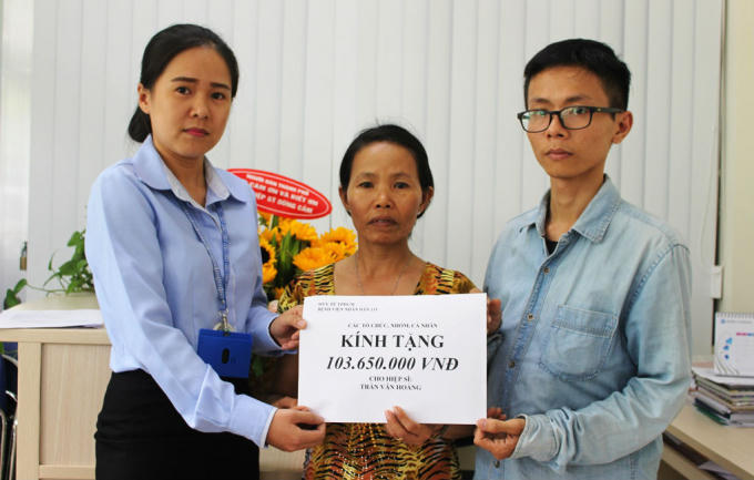 Đại diện bệnh viện trao số tiền 103 triệu đồng mà người dân TP ủng hộ cho gia đình hiệp sĩ Hoàng.