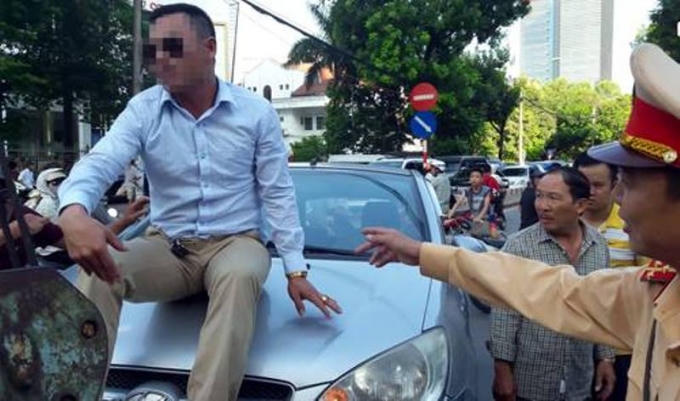 Tài xế xe ô tô "cố thủ" trên nóc capo khi xe cẩu tới.