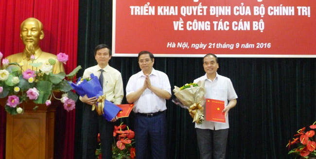 Đồng chí Phạm Minh Chính trao Quyết định của Bộ Chính trị cho đồng chí Đoàn Minh Huấn (bên trái) và đồng chí Vũ Văn Phúc (bên phải). (Ảnh: Dangcongsan.vn)