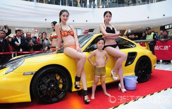 Những cô người mẫu diện bikini với cậu bé mặc quần short biểu diễn tại một cửa hàng kinh doanh ô tô ở Hàng Châu, Trung Quốc bị dư luận lên án gay gắt. Ảnh: internet.