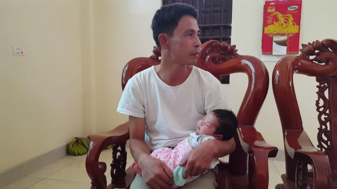Bé trai ngủ ngoan trong vòng tay cha.