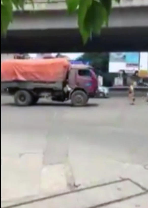 Hai CSGT chạy bộ đuổi theo xe tải lùi ngược chiều. (Ảnh cắt từ clip)