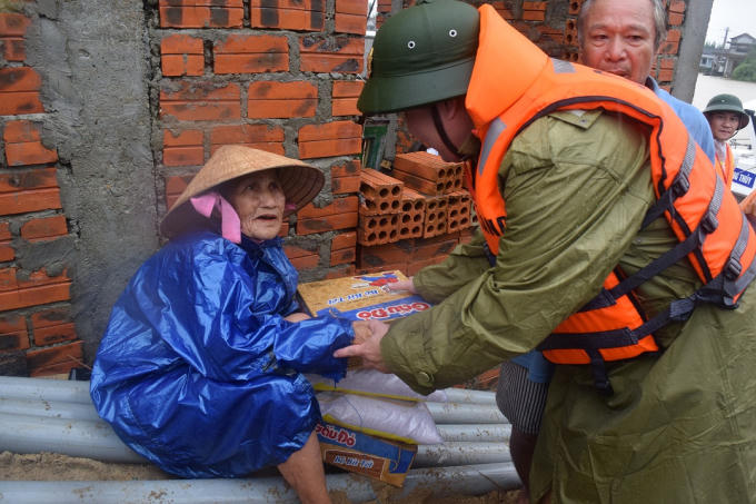 Trung tá Lê Hồng Hà tặng quà cứu trợ bão lụt cho nhân dân vùng ngập lụt.