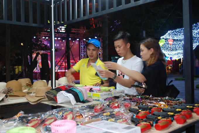 Du khách lựa chọn các sản phẩm lưu niệm được bày bán tại các quầy.