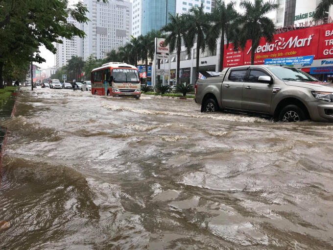 Các phương tiện tham gia giao thông bì bõm "bơi" trong biển nước.