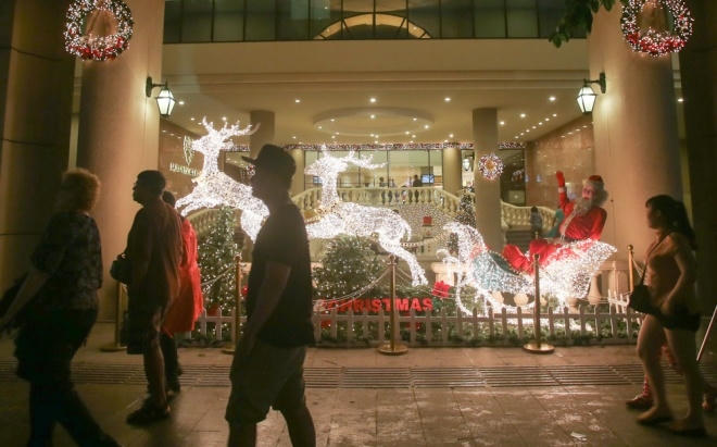 Bên ngoài một khách sạn trên đường Nguyễn Huệ là hình ảnh đàn tuần lộc kéo ông già Noel đi phát quà.