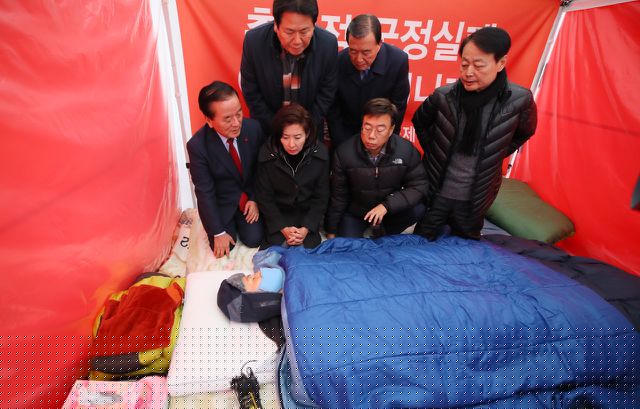 Các nghị sĩ LKP gặp gỡ chủ tịch đảng khi ông đang nằm trong lều tuyệt thực trước phủ tổng thống (Ảnh: Korea Herald)