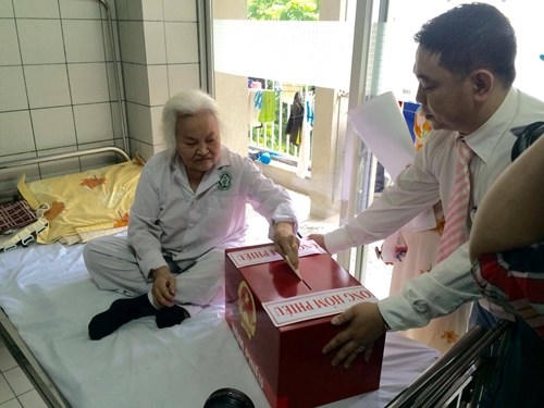 Bệnh nhân điều trị nội trú tại Khoa Cơ Xương Khớp, bệnh viện Bạch Mai thực hiện nghĩa vụ cử tri. (Ảnh tienphong.vn)