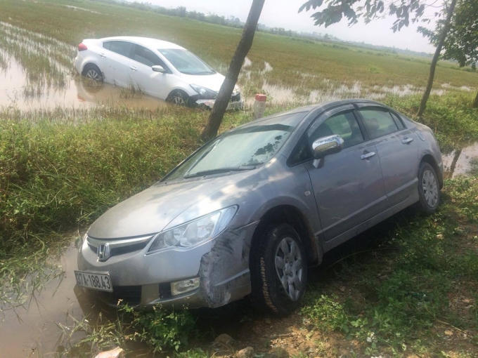 Xe KiA màu trắng "bay" qua mương nước lao thẳng xuống ruộng.