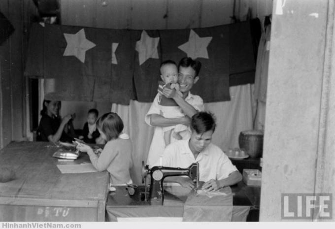 Một hiệu may, khẩn trương may những lá cờ chào đón chính quyền mới. (Ảnh: LIFE)