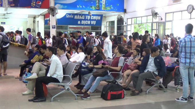 Người dân ngồi ở ghế chờ đợi để mua vé về quê.