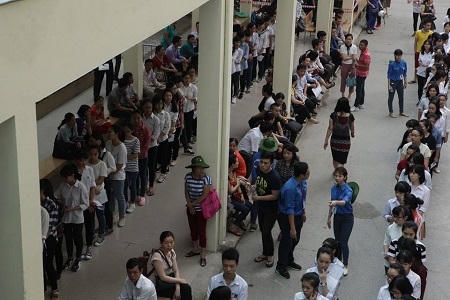 Các thí sinh xếp thành hàng dài chờ xuất trình các giấy tờ trước khi vào phòng thi.