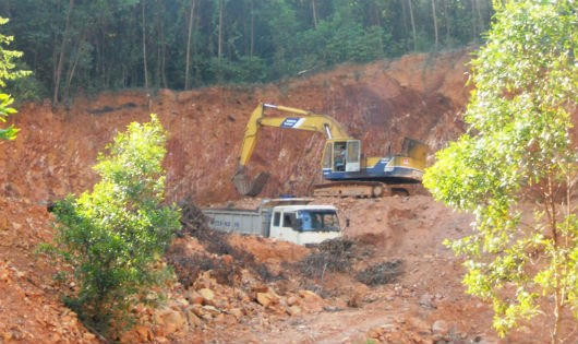 Xe đào khai thác đất tại khu vực đồi đang trồng keo thuộc địa phận thôn Trà Lương, xã Mỹ Trinh.