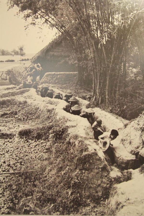 Học sinh thời chiến đội mũ rơm, đi qua h&agrave;o để đến lớp.