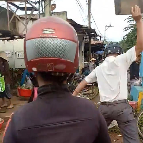 Hình ảnh ông L.T.T, trưởng công an xã Quảng Điền dùng ghế gỗ ném vào đồ. Ảnh: Cắt từ clip