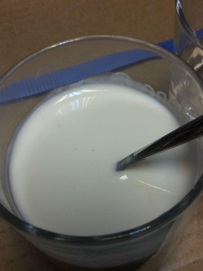 Những hạt đen nổi lợn cợn trong cốc sữa khi pha tại Siêu thị BiBo Mart trước sự chứng kiến của nhân viên siêu thị.