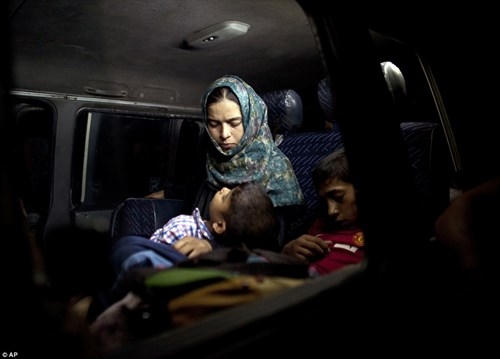 Giấc ngủ trên xe buýt sau cuộc tháo chạy vất vả. (Ảnh: AP)