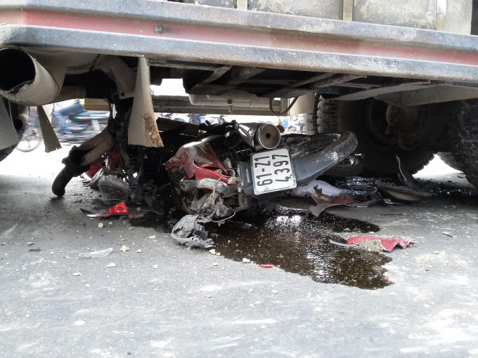 Chiếc xe máy bị cán nát vụ mắc kẹt trong gầm xe tải.