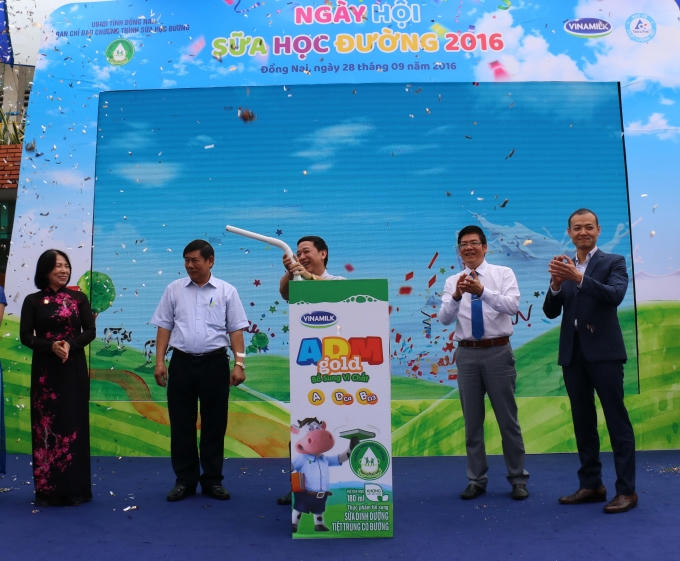Các đại biểu tham dự chương trình cùng thực hiện nghi thức cắm ống hút vào hộp sữa để chính thức khởi động chương trình Sữa học đường Quốc gia tại tỉnh Đồng Nai do Vinamilk và Tetra Pak tổ chức.