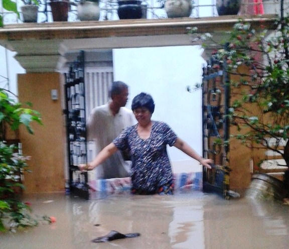 Nước ngập sâu đến bụng, người dân trên phố Hoa Bằng "bơi" trong nước.