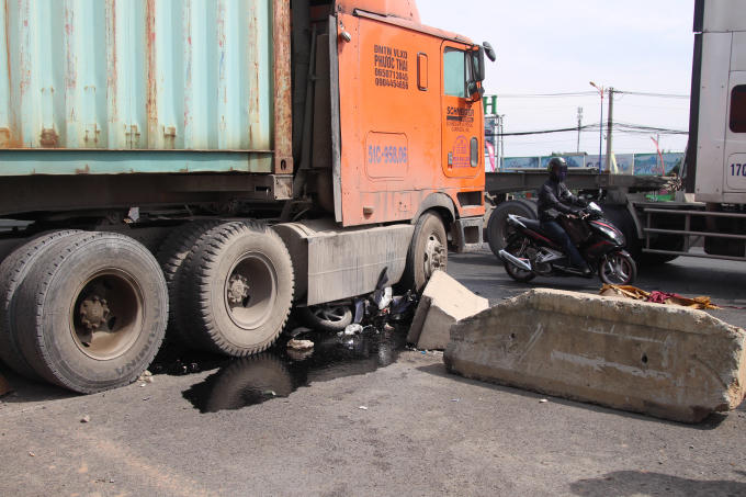 Chiếc xe máy mắc kẹt dưới gầm trước xe container.