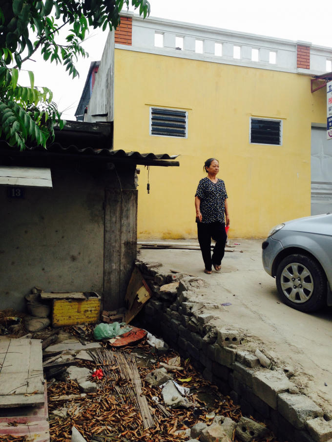 Nền căn bếp cũ của bà Oanh đã bị hàng xóm chiếm dụng làm nơi đỗ xe ô tô.