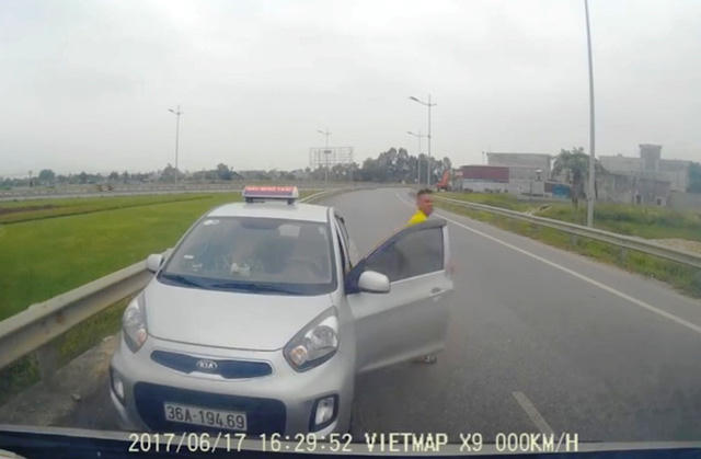 Tài xế taxi mở cửa xuống xe tiến về phương tiện chặn đầu phía trước