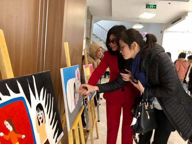 Các đại biểu tham quan trưng bày tranh của NKT đạt giải cuộc thi vẽ về bình đẳng giới và phòng, chống bạo lực gia dình.