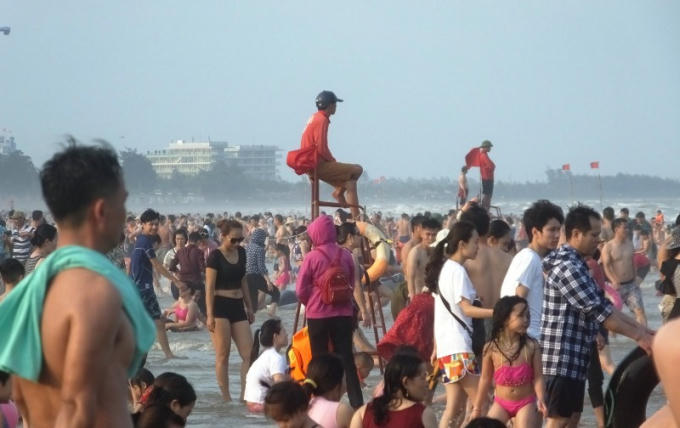 Bảo vệ ngồi trên cao để quan sát hướng dẫn du khách tắm biển được an toàn