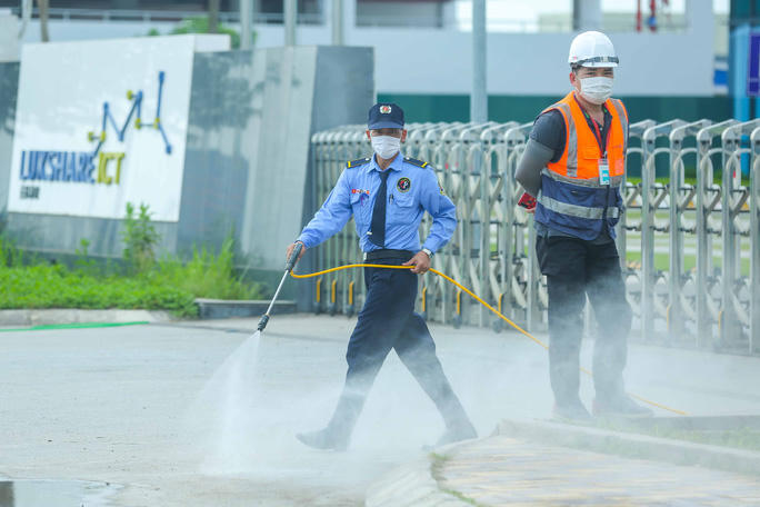 Các công nhân xét nghiệm xong, bảo vệ phun khử khuẩn toản bộ cổng ra vào công ty