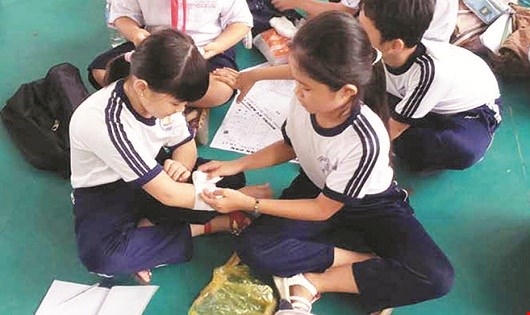 Trẻ học thực hành kỹ năng sơ cứu khi bị thương.