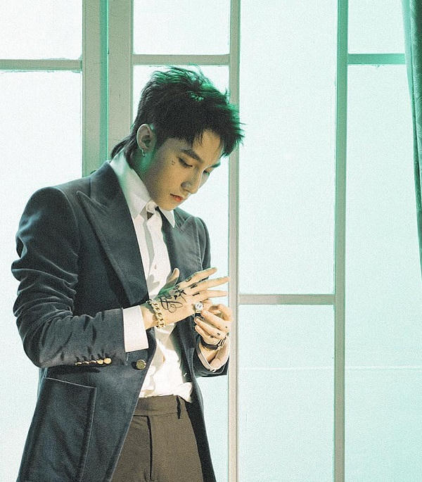 Mẫu áo vest nhung xanh của Gucci có giá 2.580 USD (khoảng 58 triệu đồng) được nam ca sĩ diện cùng sơ mi trắng nổi bật.