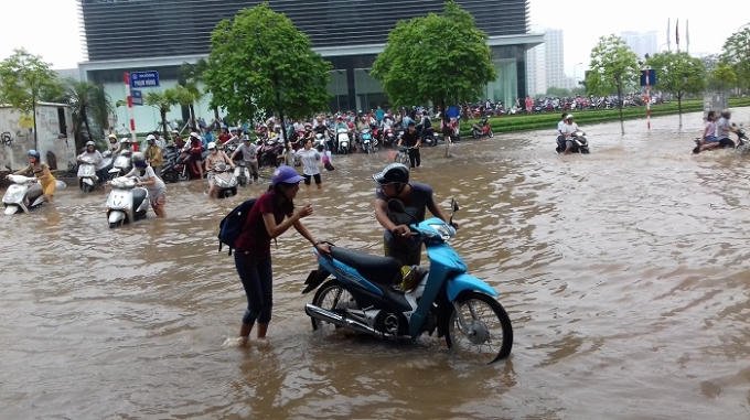 Đường ngập sâu khiến người dân di chuyển qua khu vực Keangnam phải dắt xe men theo các tòa nhà.