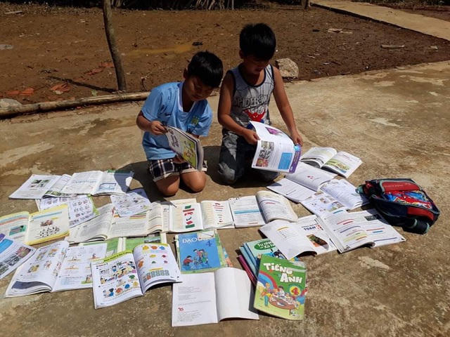 Sách vở của học sinh cũng lấm lem bùn đất, ướt sũng.