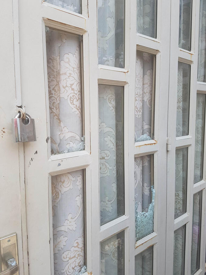Cửa kính nhà bà Hồng bị đập phá hư hỏng.