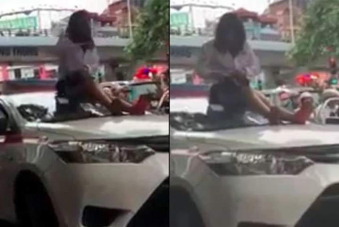 Bị lực lượng CSGT dừng xe, nữ tài xế taxi trèo lên nóc xe ăn vạ.