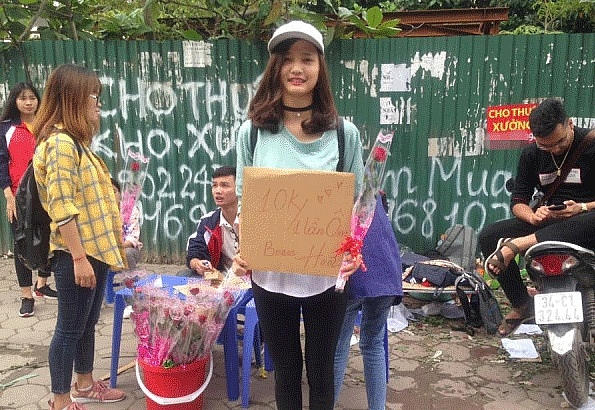  Các bạn nữ với tấm biển rao bán ôm và tặng hoa.