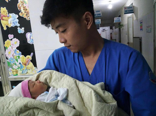 Bé trai được các nhân viên y tế chăm sóc. (Nguồn: CTV)