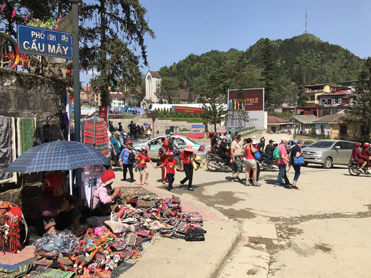 Những người bản địa bày bán hàng trên vỉa hè đầy bụi bặm, con đường nhếch nhác những bụi bẩn, nước và rác.