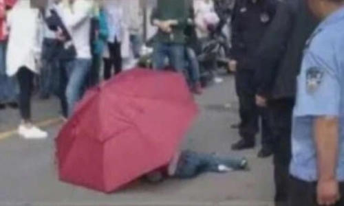 Bé trai người Trung Quốc dùng ô nhảy từ nhà cao tầng xuống đất.