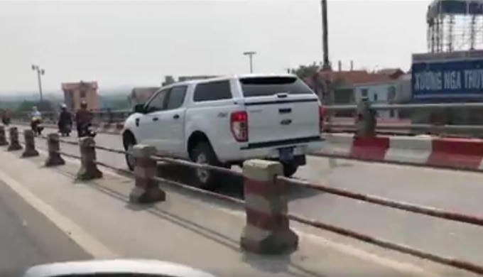 Một xe ô tô biển xanh được cho là đã đi vào làn đường dành cho xe máy trên cầu Thanh Trì. (Ảnh cắt từ clip)