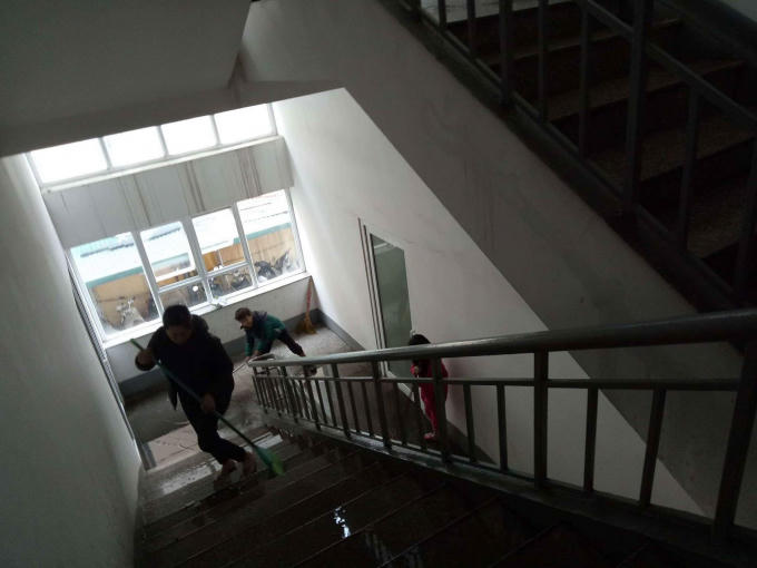 Người dân trở lại phòng dọn dẹp và lau chùi hành lang sau khi Lính cứu hỏa khống chế hoàn toàn vụ cháy.