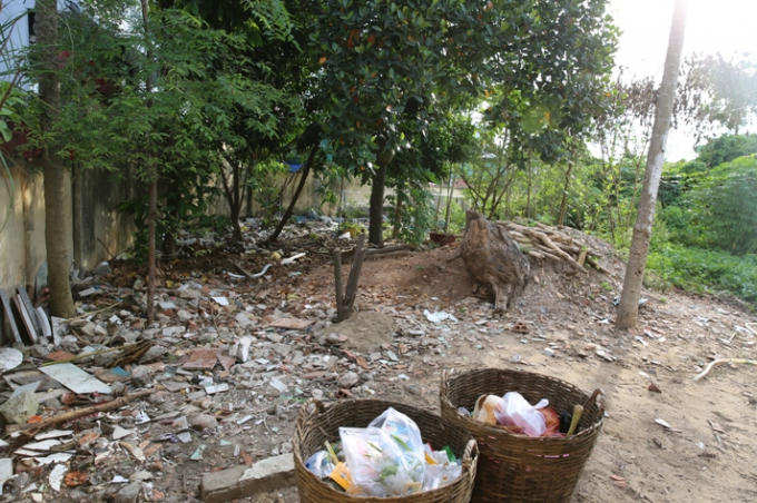 Phía trong cổng tràn ngập cỏ rác.