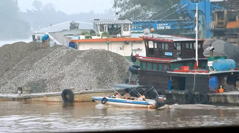 Ca nô CSGT cặp sát sà lan, người trên sà lan chạy ra luống cuống làm rơi “tờ nhỏ” khỏi bìa nhựa, nên lượm đưa vào lại rồi chuyển CSGTẢNH: CÔNG NGUYÊN