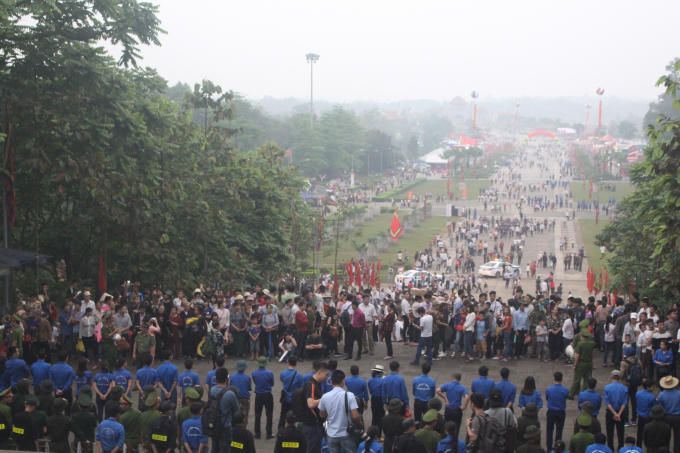Lực lượng chiến sĩ công an và sinh viên tình nguyện đứng thành hàng rào nhằm tránh tình trạng bà con chen lấn, xô đẩy nhau dưới trời mưa.