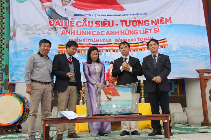 Đại diện Hội người Việt Nam giới thiệu tranh phiên bản bức tranh cát "Gạc Ma - Vòng tròn bất tử".