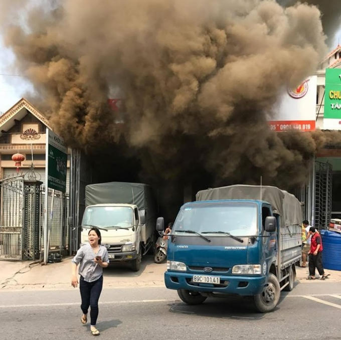 Ngọn lửa bùng phát ra từ kho hàng, người dân hoảng hốt thoát nạn. Ảnh bạn đọc cung cấp.