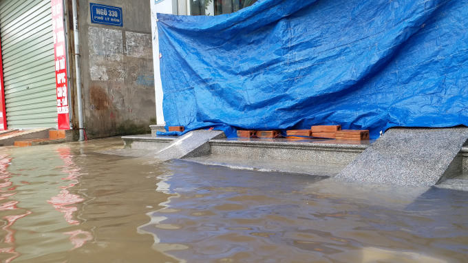 Cứ mỗi trận mưa, các hoạt động kinh doanh trên tuyến phố này gần như tê liệt. Các cửa hàng phải che bạt, đóng cửa tránh nước.